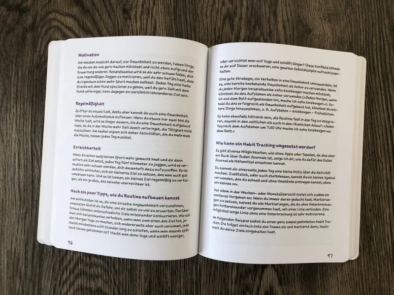 Aufgeschlagenes Praxisbuch mit Texterläuterung zu Motivation und Habit Tracking
