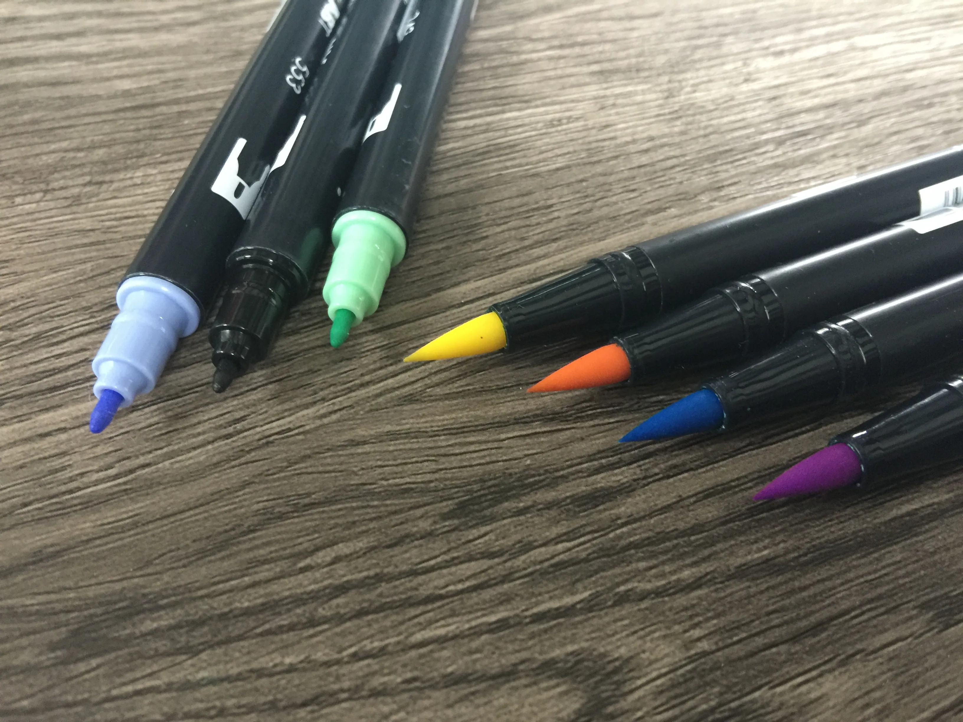 Nahaufnahme der Pinselspitzen mehrerer Tombow Brushpens in verschiedenen Farben