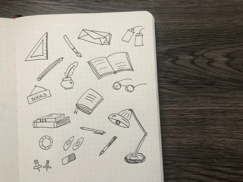 Doodles von Schreibwaren mit Lineal, aufgeschlagenem Buch, Brille und Schreibtischlampe