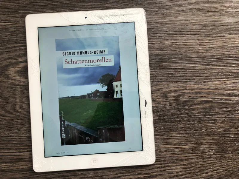 iPad mit gesprungenem Display zeigt das E-Book-Cover des Kriminalromans Schattenmorellen