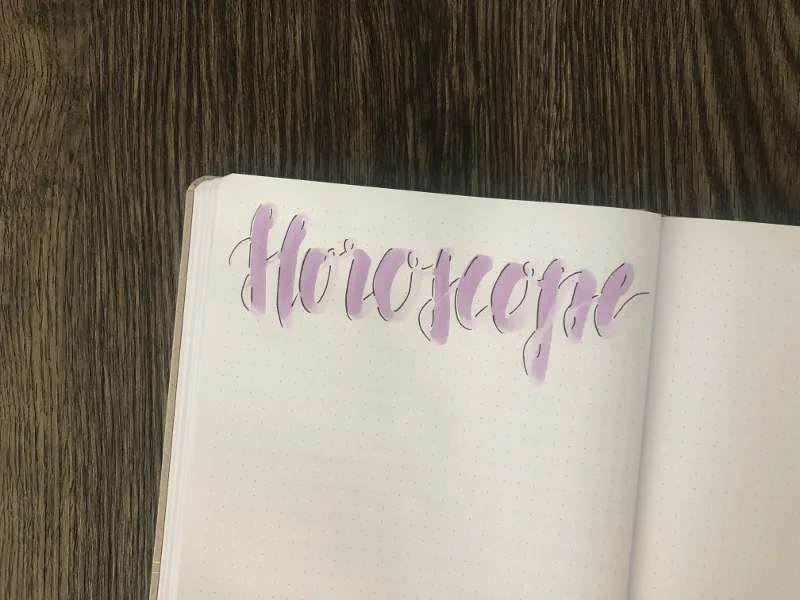 Handlettering-Überschrift Horoscope in Lila auf gepunkteter Seite