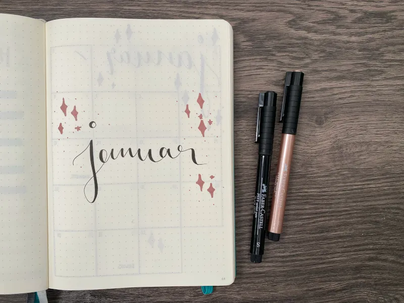Januar-Deckblatt mit Handlettering und zwei Faber-Castell-Stiften daneben
