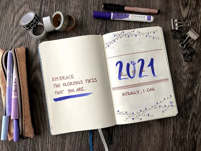 Bullet-Journal-Deckblatt mit Schriftzug 2021 und Handlettering zwischen Washi-Tape und Brushpens