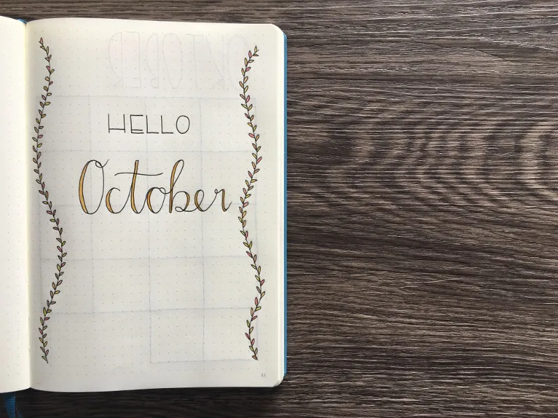 Schlichtes Oktober-Deckblatt im Bullet Journal mit dem Schriftzug HELLO October, links und rechts gerahmt von zwei feinen Blattranken