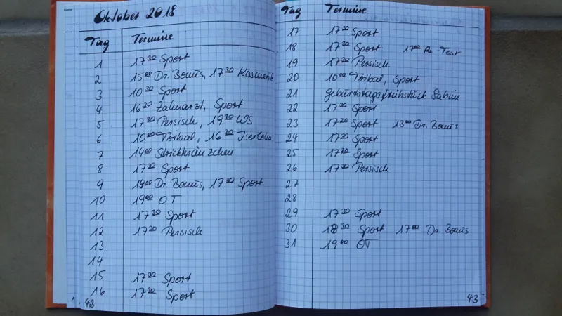 Handschriftliche Monatsübersicht Oktober 2018 in einem karierten Notizbuch mit Sport- und Arztterminen