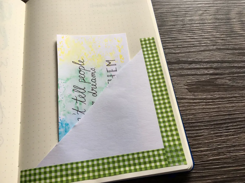 Grünes Karo-Washi-Tape als Ecke mit Aquarellkarte im Notizbuch